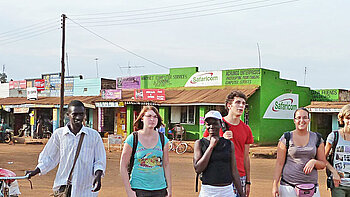 Die Teilnehmenden auf einer Straße mit Läden in Tansania